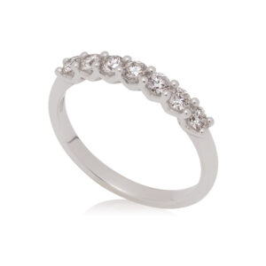 A platinum round brilliant cut diamond seven stone half eternity ring.