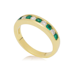 An 18ct yellow gold emerald and diamond channel set half eternity ring, containing nine stones.